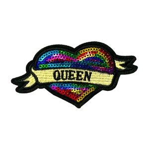 May include: A rainbow sequin heart with a black embroidered banner that says "QUEEN".