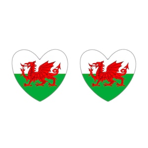 May include: Two heart-shaped stickers with the Welsh flag. The flag features a red dragon on a white background with a green field at the bottom.
