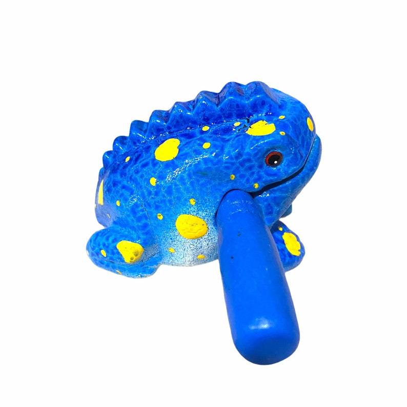 Peut inclure: Instrument de musique en forme de grenouille bleue avec des taches jaunes et une poign&eacute;e bleue.