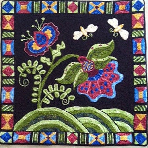 Puede incluir: Una alfombra negra con un diseño floral colorido. La alfombra presenta una gran flor roja con detalles azules y blancos, rodeada de hojas verdes y flores más pequeñas. La alfombra tiene un borde geométrico en tonos de rojo, azul, amarillo y verde.