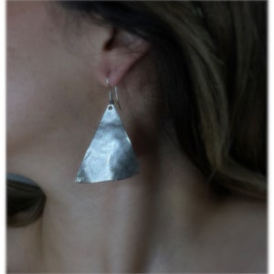 Puede incluir: Pendientes triangulares de plata con textura martillada.