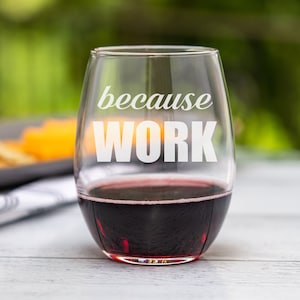 May include: A clear glass wine glass with the text "because work" etched on the side. The glass is filled with red wine.