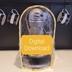Op de afbeelding: Een transparante plastic hoes met een gele en witte geruite rand voor een KitchenAid-standmixer. De hoes heeft een geel label met de tekst "Digitale download".