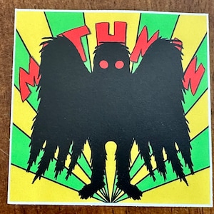 May include: A black and red illustration of a creature with large wings and red eyes. The creature is standing on a yellow and green background with the word "MOTHMAN" in red letters.
