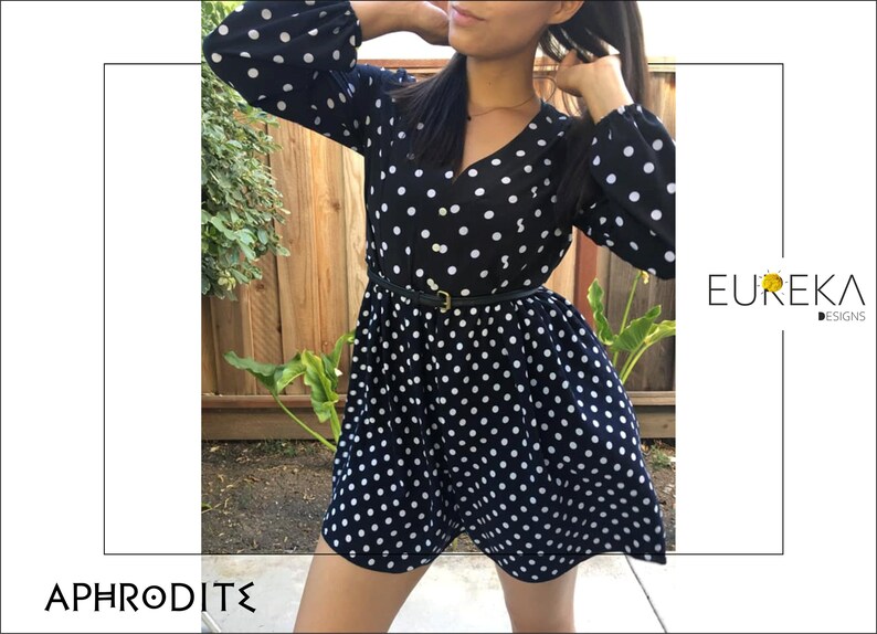 May include: A black and white polka dot romper with long sleeves and a V-neck. The romper is cinched at the waist with a black belt. The image also includes the text "APHRODITE" and "EUREKA DESIGNS".
