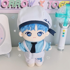 May include: A plush doll with blue hair, wearing a white sailor hat with blue trim and a navy tie. The doll has blue eyes and is dressed in a light blue shirt and white pants with a dolphin design. A light stick is in the background.