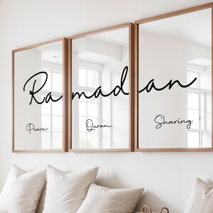 May include: Three framed mirrors with wooden frames are displayed on a white wall. Each mirror has the word "Ramadan" written in a cursive font, with the words "Peace", "Quran", and "Sharing" below.