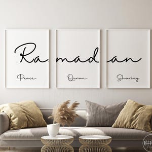 May include: Three framed art prints with the word "Ramadan" in elegant black script. Each print features a different word below: "Peace," "Quran," and "Sharing." The prints are displayed above a gray sofa with decorative pillows.