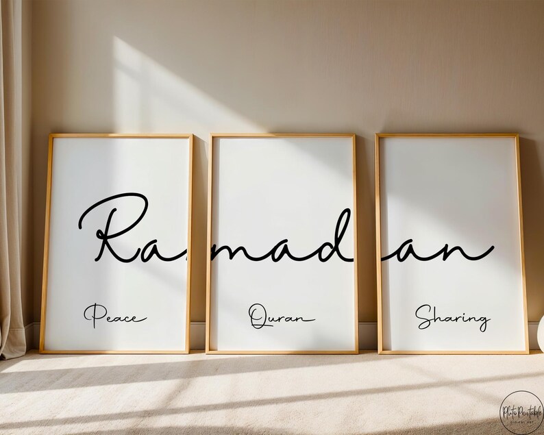 May include: Three framed art prints with gold frames. Each print has the word "Ramadan" in black script. Below each word is a smaller word: "Peace", "Quran", and "Sharing". The prints are on a white background.