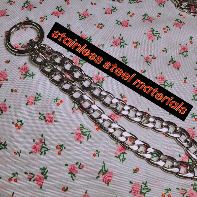 Puede incluir: Un collar de cadena plateado con un colgante redondo abierto de gran tama&ntilde;o. La cadena es de acero inoxidable y tiene un dise&ntilde;o de eslab&oacute;n de curb. El colgante est&aacute; unido a la cadena con un peque&ntilde;o anillo plateado.