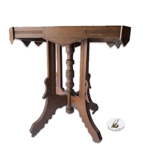 May include: A dark brown wooden table with a square top and intricate carvings. The table has four legs with decorative details and a central pedestal.