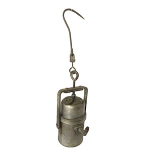 May include: A vintage metal miner's lamp with a hook for hanging. The lamp has a cylindrical body with a small spout and a metal handle.
