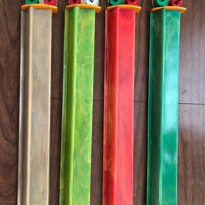 Puede incluir: Cuatro piezas de juego vintage en tonos beige, verde, rojo y verde. Cada pieza tiene una columna rectangular con una parte superior decorativa con clavijas de colores. Las partes superiores tienen herrajes de lat&oacute;n y est&aacute;n montadas sobre una base naranja.