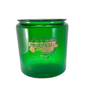May include: A vintage green glass jar with a black rim. The jar has a faded label that reads "Praktikal" and "Long Island City". The jar is a humidifier.
