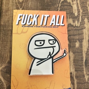 Puede incluir: Un pin con un personaje estilo meme haciendo una peineta. El pin está en una tarjeta con el texto "FUCK IT ALL EXPRESS YOUR FUCKING SELF" en letras blancas. El fondo es naranja con dedos medios dibujados a mano.