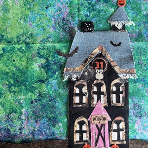 Peut inclure: Une maison d'Halloween faite à la main en tissu et en papier. La maison a un toit en jean, des murs noirs et des éléments décoratifs tels que des chauves-souris, des citrouilles et le chiffre 31. Les mots "Pick Your Poison" sont visibles.