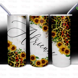 May include: Three stainless steel tumblers with different designs. The first tumbler has a leopard print with sunflowers. The second tumbler has a sunflower design with the word "Friends" written in cursive. The third tumbler has a white background with a leopard print and sunflowers.