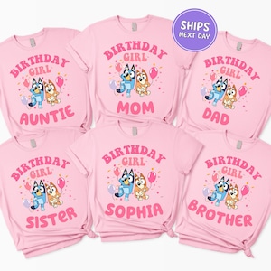 A collection of pink t-shirts with the text "BIRTHDAY GIRL" printed on them, along with illustrations of cartoon dogs.