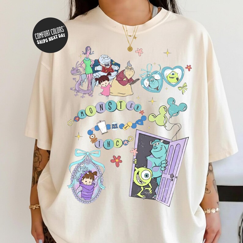 a person wearing a white t-shirt with a colorful graphic design depicting various cartoon characters and scenes from the movie Monsters, Inc.