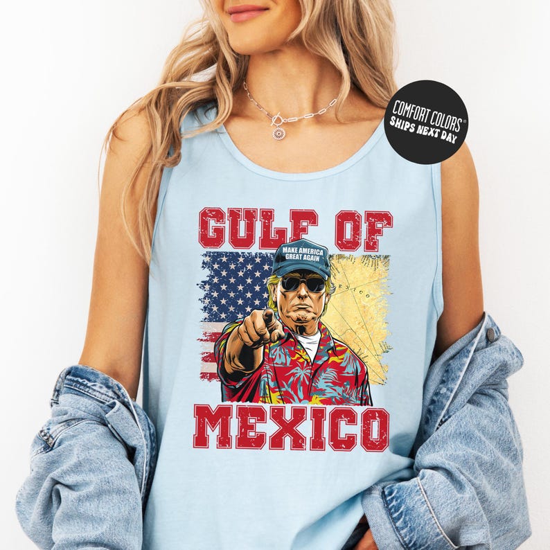 A woman wearing a tank top with a graphic design of a man pointing at the word "GULF" and "MEXICO" printed on it.