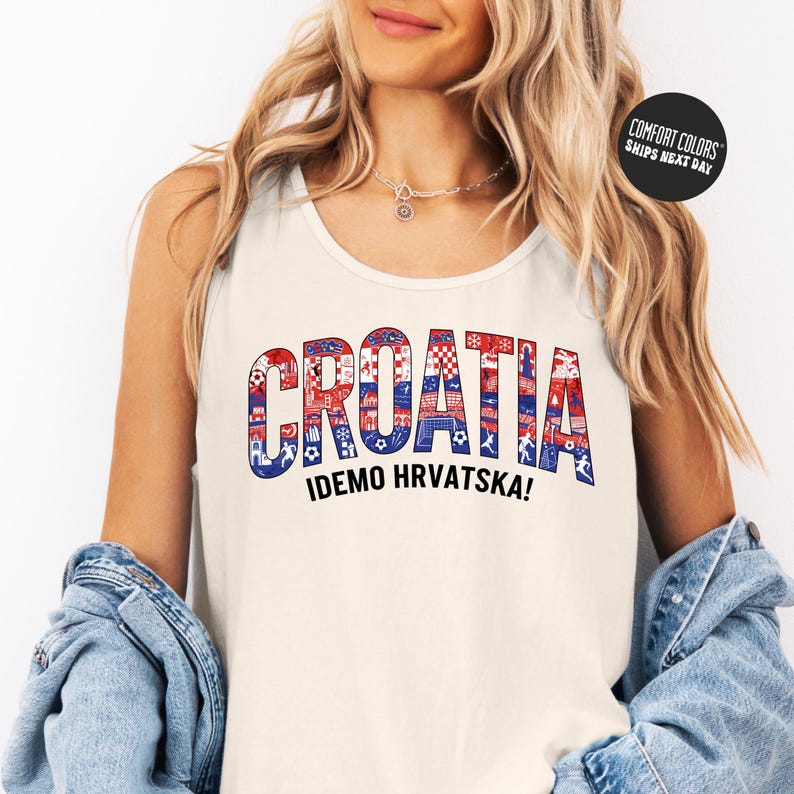 A woman wearing a white tank top with the word "Croatia" printed on it, along with the text "IDEMO HRVATSKA!" The woman is also wearing a denim jacket and has her hands in her pockets.