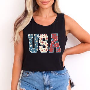 a woman wearing a black usa tank top