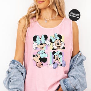 A woman wearing a pink tank top with a Minnie Mouse design and a denim jacket.