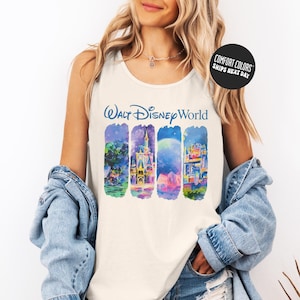 A woman wearing a white tank top with a Disney World graphic and a denim jacket, smiling at the camera.