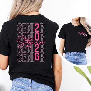 a woman wearing a black shirt with pink letters on it