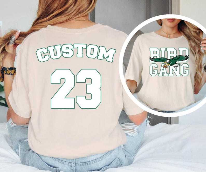 A woman wearing a white t-shirt with the text "CUSTOM 23" printed on it, along with a graphic of a bird.