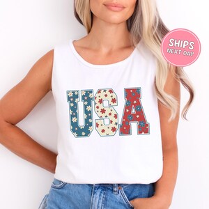 a woman wearing a tank top with the word usa printed on it