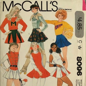 May include: A vintage sewing pattern for a cheerleader outfit. The pattern includes four different skirt styles, with a red, white and blue colour scheme. The pattern is for size 10, bust 32 1/2 inches. The pattern is from McCall's and is number 8096.