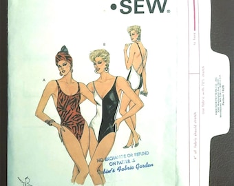 May include: A Kwik Sew pattern envelope 1625 for sizes 4-6-8-10 featuring illustrations of three one-piece swimsuits. One swimsuit has a brown and black tiger print, while the others are black and white. The envelope includes a barcode and text.
