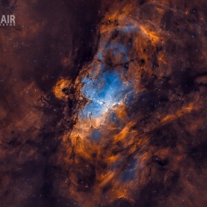 May include: A vibrant nebula in space with swirling orange and blue hues. The nebula is filled with stars and has a dark, almost black background.