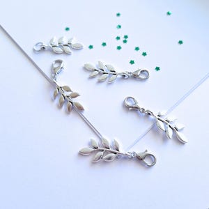 Silverfärgad olivkvist-klippberlock: Dragkedja, väskhänge (23 x 10 mm)