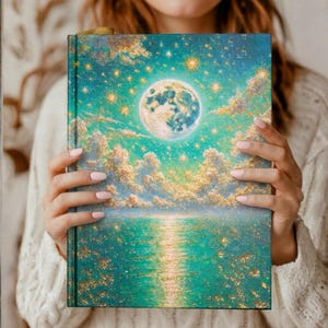 Könnte beinhalten: Ein Hardcover-Journal mit einem Himmelsdesign. Das Cover zeigt einen Vollmond, Sterne und Wolken über Wasser, in Türkis, Gold und Weiß. Das Journal wird von einer Person gehalten.