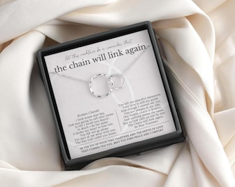 May include: A silver necklace with two interlocking circles, presented in a black box with a white card. The card features the text "let this necklace be a reminder that the chain will link again" and a poem.