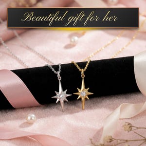 K&ouml;nnte beinhalten: Zwei Stern-Anh&auml;nger-Halsketten, eine silberne und eine goldene, auf einer schwarzen Samtoberfl&auml;che. Jede Halskette hat einen zentralen Edelstein. Das Bild enth&auml;lt den Text "Beautiful gift for her" in goldener Schrift.