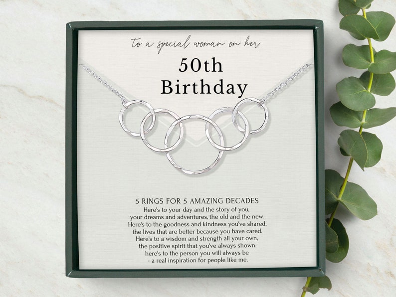 The Sterling Silver necklace for 50th birthday gift for her with 5 interlocking circles. The necklace is 18 inches long with an adjustable ring at 16 inches. The pendant measures 2.3 inches in width and 0.65 inches in height.