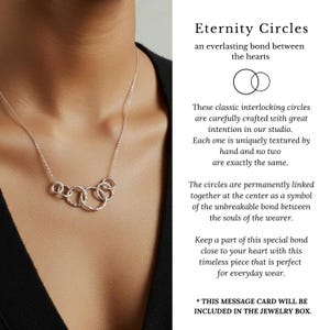 May include: A silver necklace featuring five interlocking circles. The necklace is displayed on a person wearing a black top. The text on the right side of the image reads "Eternity Circles".