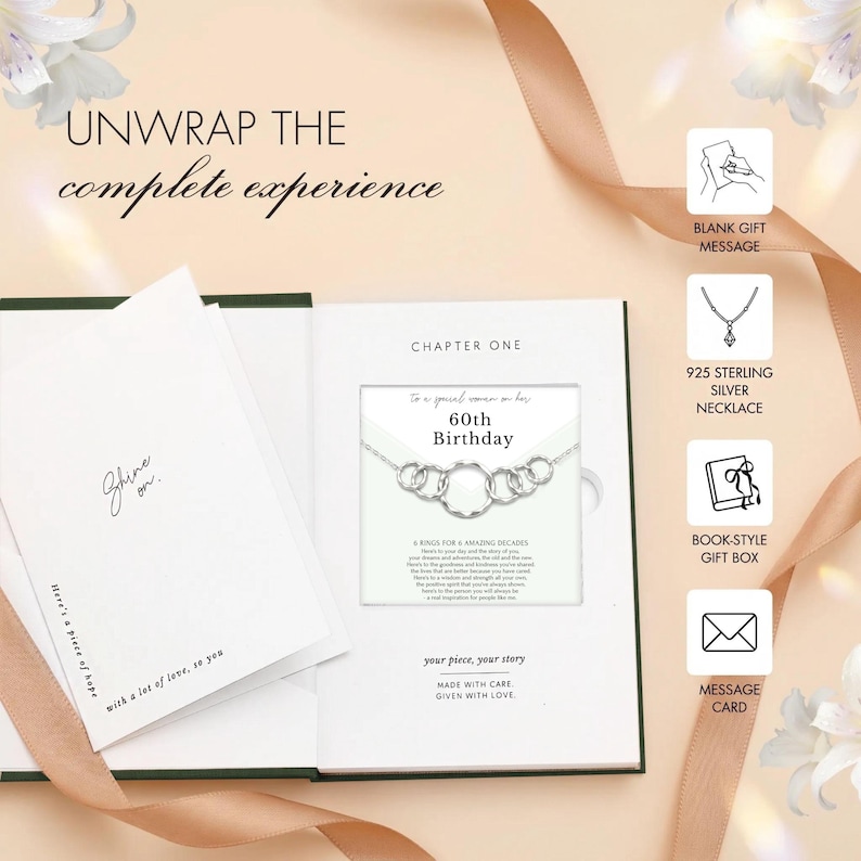 May include: A book-style gift box with a silver necklace, perfect for a 60th birthday. The necklace features six interlocking rings. The box includes a message card and a blank gift message option. Text on the box reads "Unwrap the complete experience."