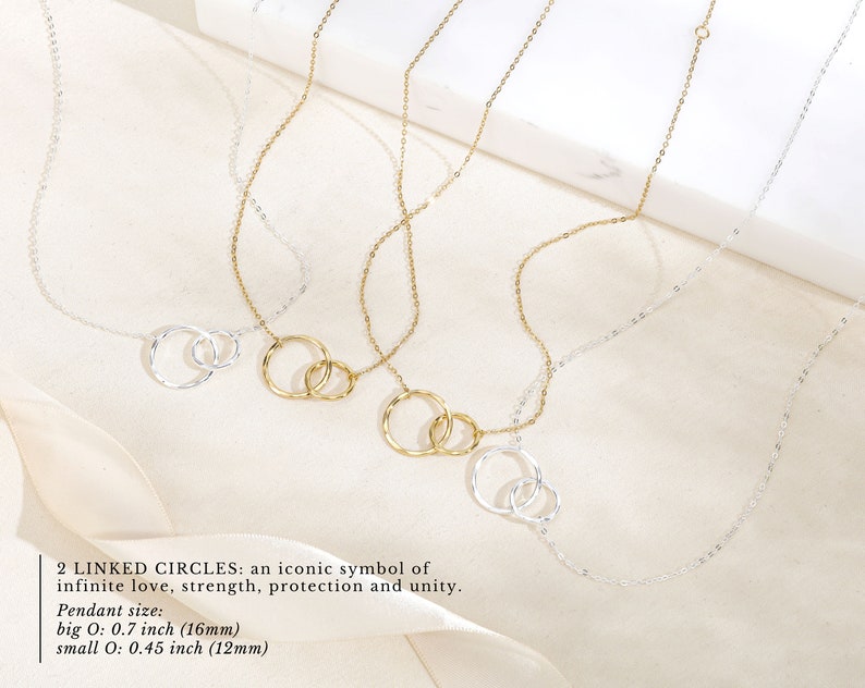 Say goodbye with our sentimental farewell gift, a beautiful reminder of cherished memories shared. This 14k gold and sterling silver necklace features two linked circles, an iconic symbol of infinite love, strength, protection, and unity.