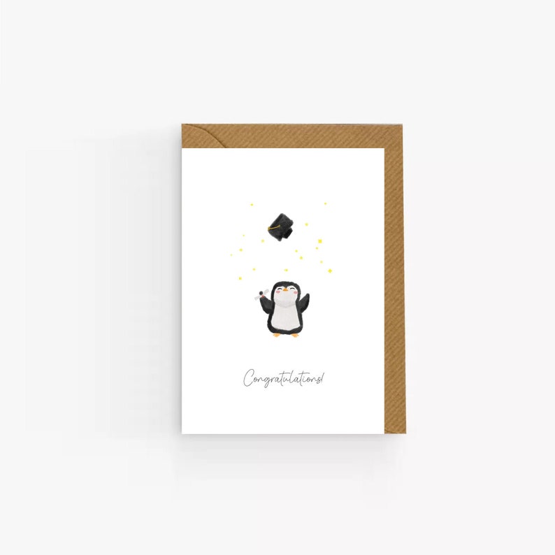 May include: A white card with a penguin wearing a graduation cap and holding a diploma. The penguin is surrounded by small yellow stars. The card reads "Congratulations!"