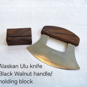 Peut inclure: Couteau ulu d'Alaska avec manche en noyer noir et bloc de maintien en bois assorti.