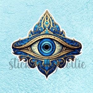 May include: A blue and gold evil eye with intricate details. The eye is surrounded by a decorative frame with a floral pattern.