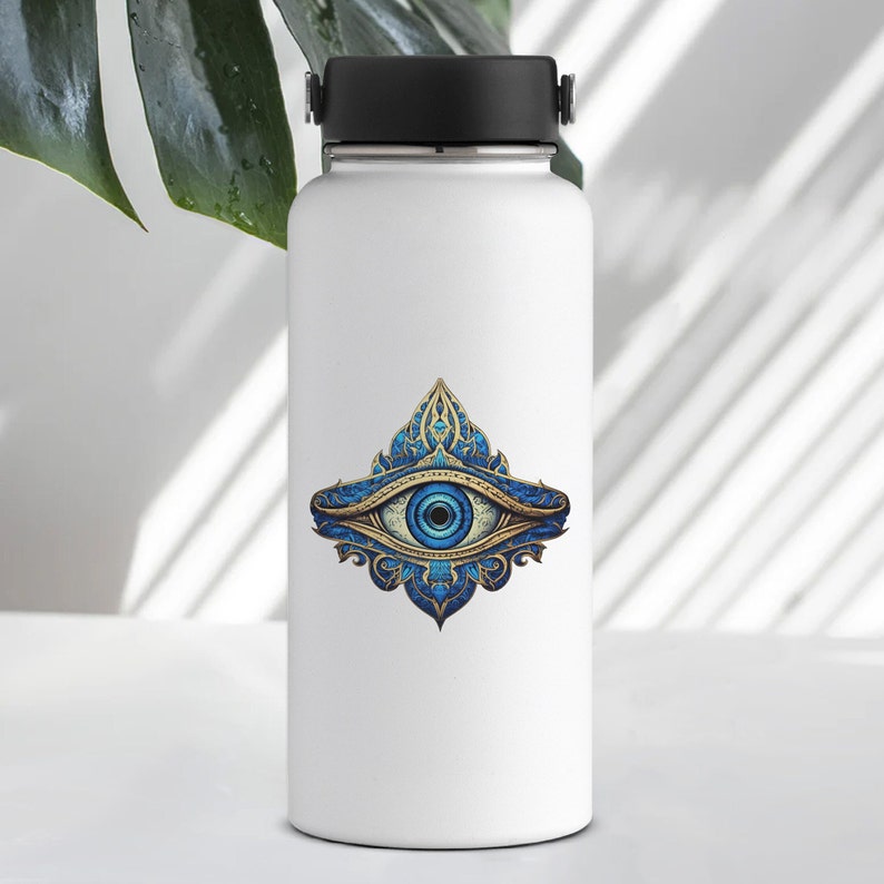 May include: White water bottle with a blue and gold eye design sticker. The eye is surrounded by intricate floral patterns.