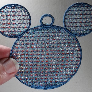 May include: Blue and red embroidered Mickey Mouse ornament with a loop for hanging.