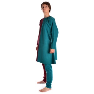 May include: A teal and burgundy tunic with long sleeves and a loose fit. The tunic is made of a soft, comfortable fabric and has a simple, elegant design.