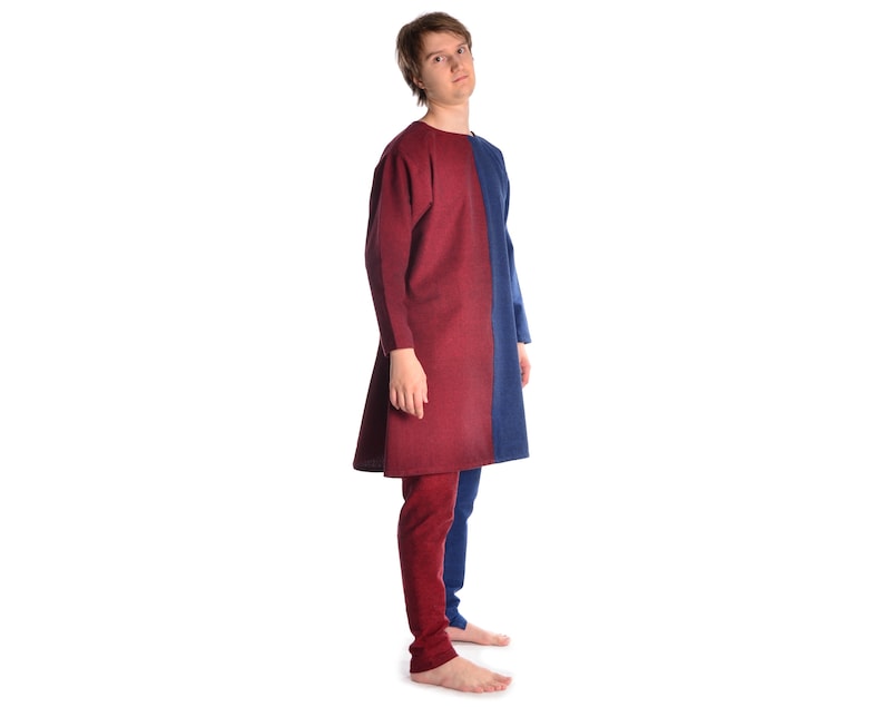 May include: A person wearing a long-sleeved tunic with a red and blue color block design. The tunic has a simple, loose fit and is made of a soft, textured fabric.