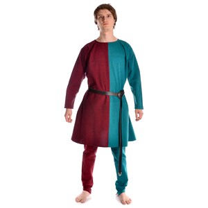 May include: A long-sleeved tunic with a burgundy and teal color block design. The tunic has a simple neckline and a belt at the waist.